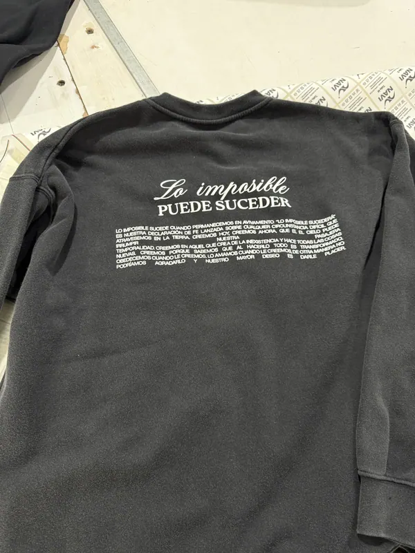 Buzo cuello redondo negro con estampa de texto en la espalda