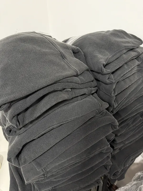 Buzos lavados gris oscuro apilados en el taller