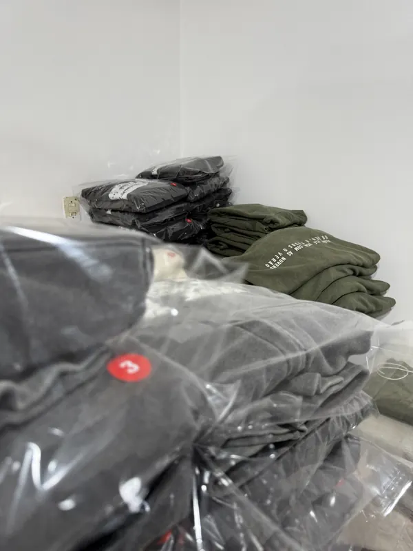 Buzos negros y verdes embolsados y numerados por talle