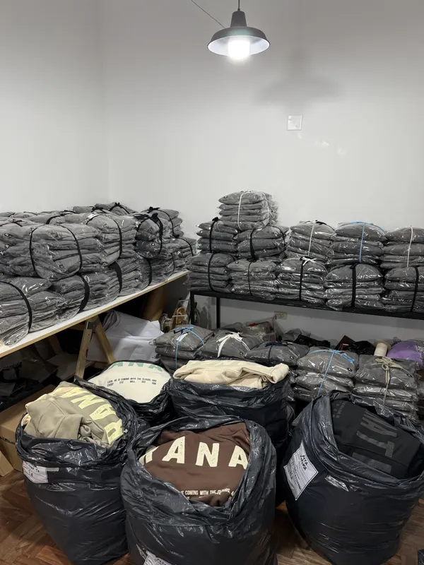 Depósito del taller con buzos embolsados y pedidos listos para entregar