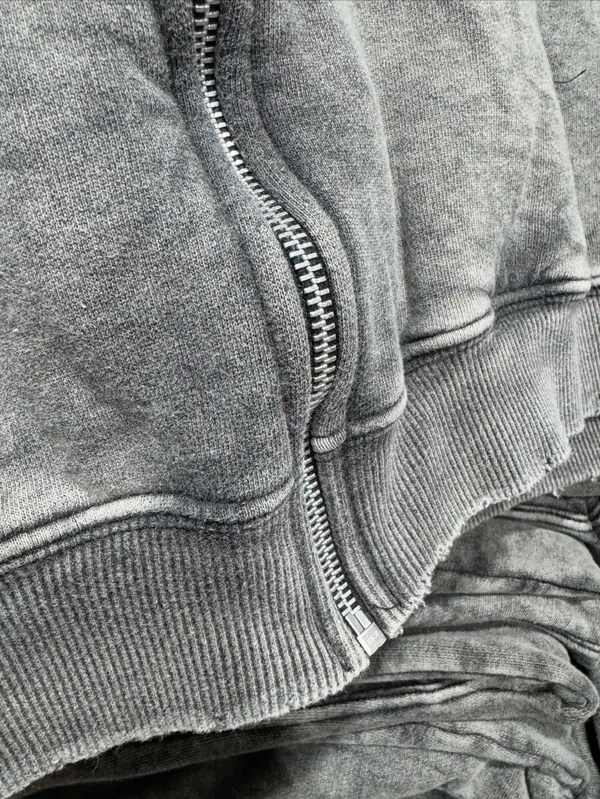 Detalle de un buzo con cierre en algodón lavado gris
