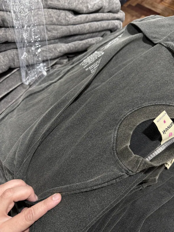 Detalle de remera de algodón lavado negro con etiqueta propia