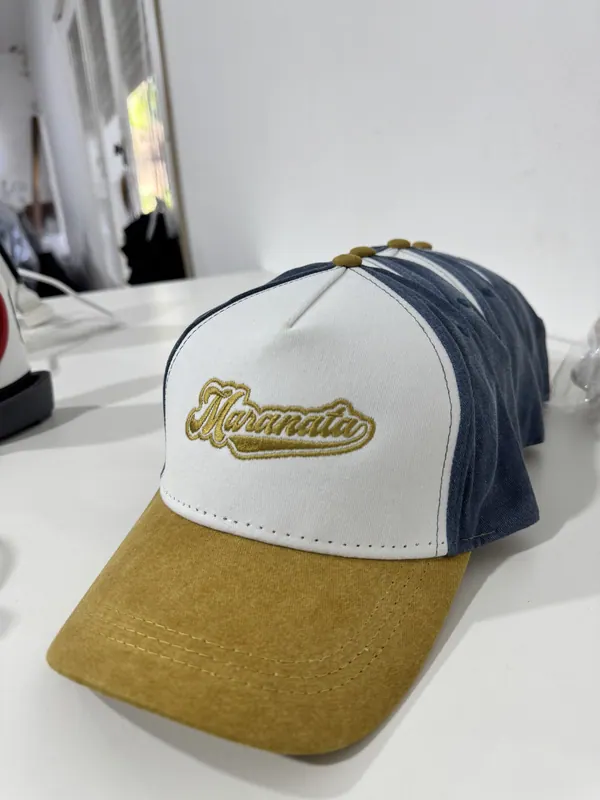 Gorra trucker azul, blanca y mostaza con bordado dorado