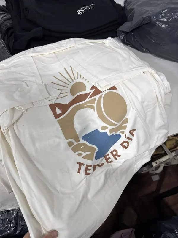 Remera crema con estampa a color en la espalda, merch para iglesia