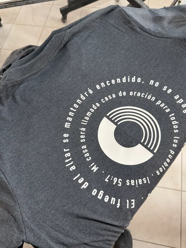 Remera gris con estampa circular en la espalda, merch para iglesia