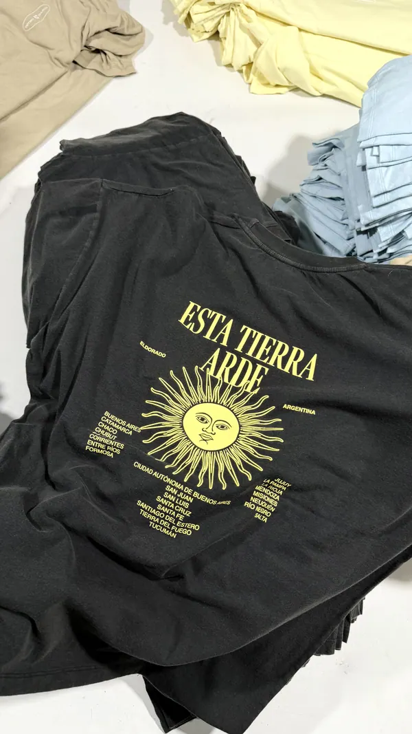Remera negra con estampa amarilla de un sol en la espalda, merch para iglesia