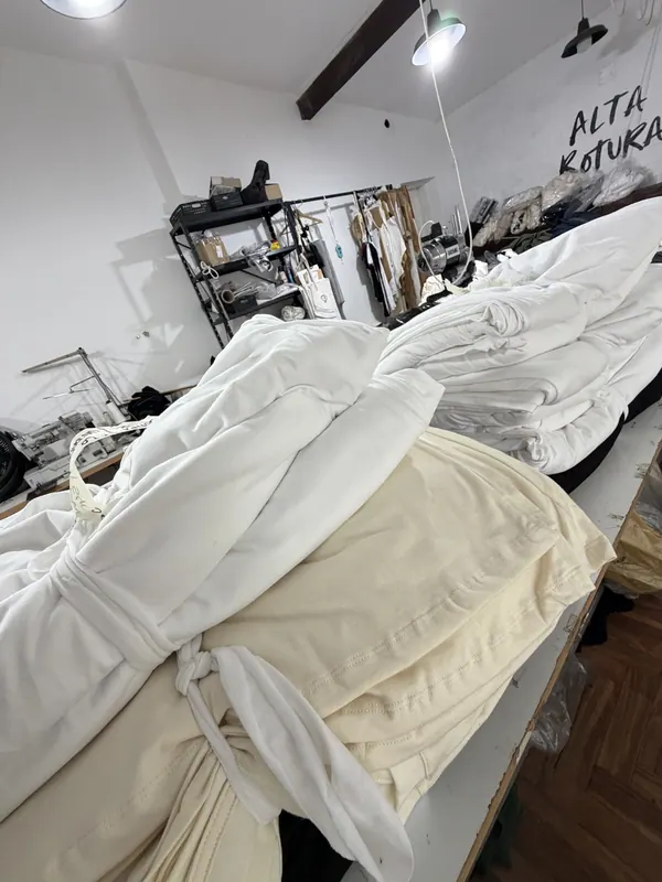 Remeras blancas en producción sobre la mesa del taller