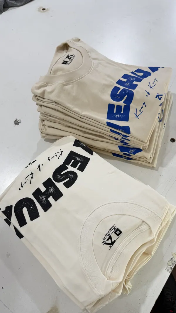 Remeras crema estampadas apiladas, pedido para iglesia