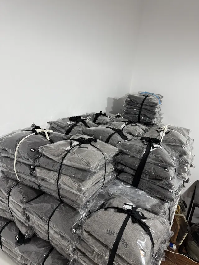 Buzos grises embolsados y atados por talle, producción de merch por mayor lista para despachar